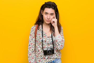 Wall Mural - Young brunette traveler woman pointing temple with finger, thinking, focused on a task.