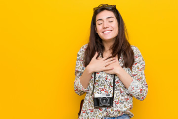 Wall Mural - Young brunette traveler woman laughing keeping hands on heart, concept of happiness.