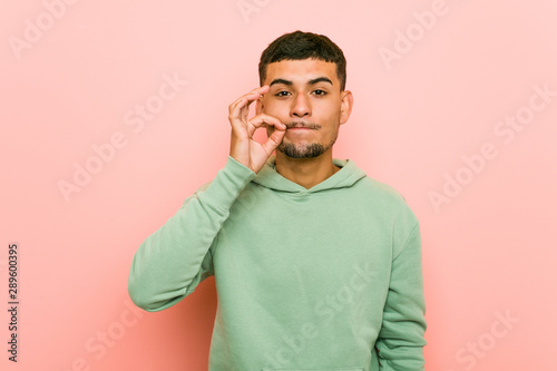 Cuadros en Lienzo Young hispanic sport man with fingers on lips keeping a secret.