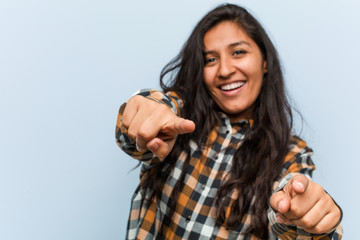 Wall Mural - Young cool indian woman cheerful smiles pointing to front.