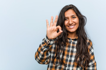 Wall Mural - Young cool indian woman cheerful and confident showing ok gesture.