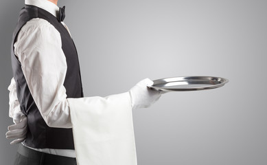 Wall Mural - Waiter serving with white gloves and steel tray in an empty space