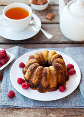 Wall Mural - Chocolate marble bundt cake with a cup of tea on wooden background.