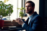 Fototapeta  - businessman sitting at table with cup of coffee