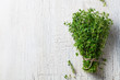 Bunch of fresh thyme on cracked white wooden background. Top view. Copy space.