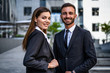 © Artem - The happy business man and woman standing on the urban background
