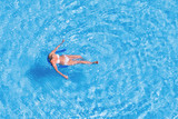Fototapeta  - Woman in an outdoor pool, top view.