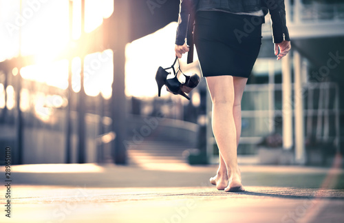 Cuadros en Lienzo Woman holding high heels in hand and walking home from party barefoot