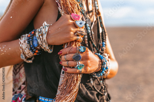 Fotomural close up of young boho style woman hands with lots of accessories