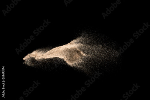 Dry river sand explosion. Golden colored sand splash against  black background.