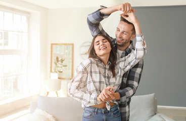 Poster - Happy young couple dancing at home