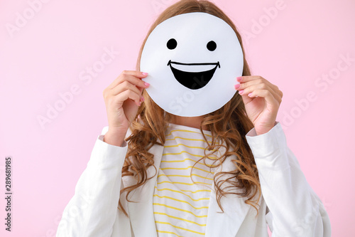 Cuadros en Lienzo Woman hiding face behind emoticon on color background
