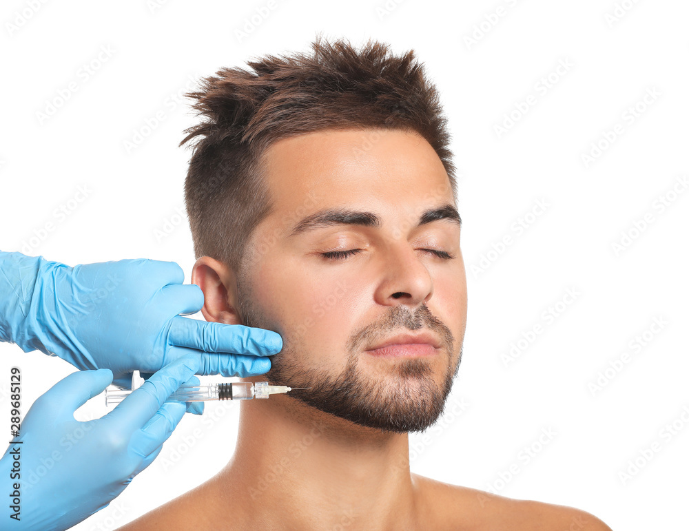 Handsome man receiving filler injection on white background