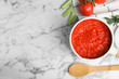 Flat lay composition with delicious tomato sauce on marble table. Space for text