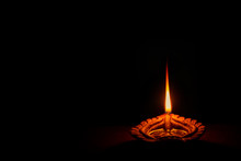 Happy Diwali. Background Picture Of Traditional Diya Clay Oil Lamp Lit At Dark Night On Diwali With Copy Space In Landscape Format.