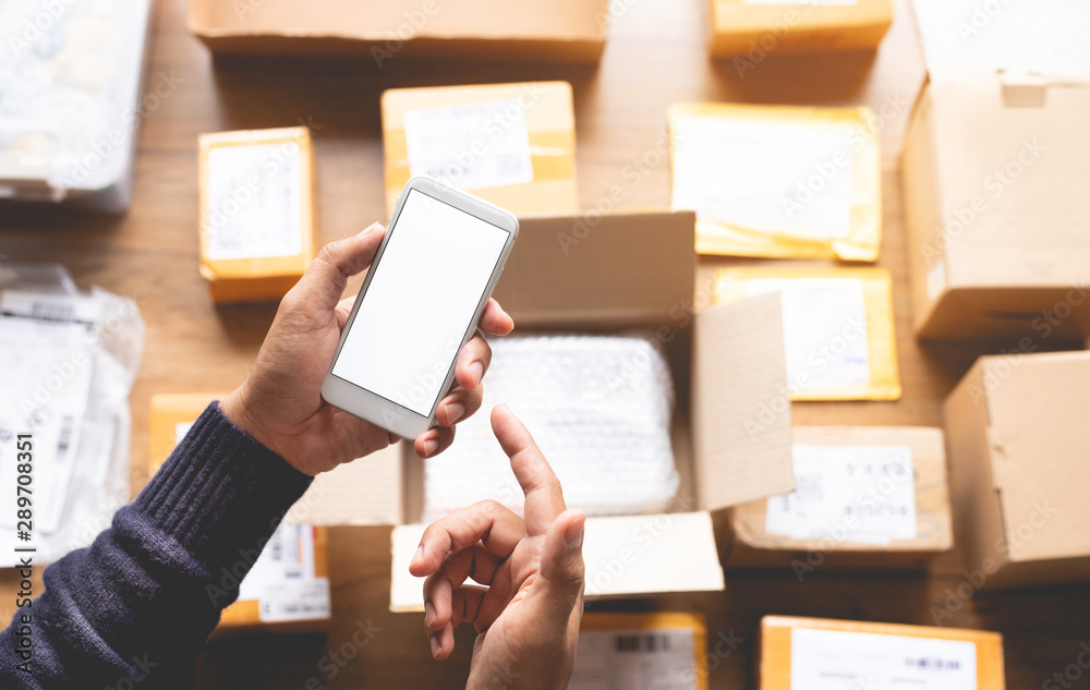 Online shopping concepts with youngman using smartphone on a lot of package box.Ecommerce market.Transportation logistic - obrazy, fototapety, plakaty 
