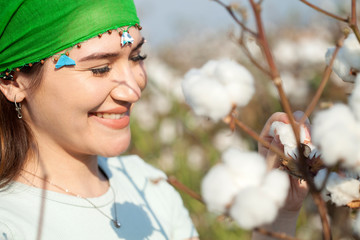 Wall Mural - young woman farmer at cotton cultivated field