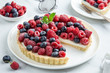 blueberry  and raspberry tart  on white marble background