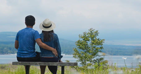 Wall Mural - Couple sit together in the park and look at the landscape