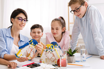 Poster - Teacher showing modern robot to children in classroom