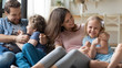 © fizkes - Overjoyed excited family playing together on couch at home.