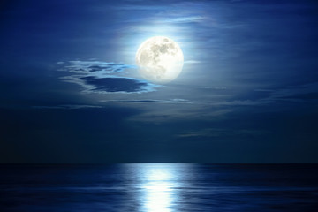 super full moon and cloud in the blue sky above the ocean horizon at midnight, moonlight reflect the