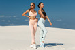 Beautiful fitness models in sportswear. Couple athletic girls in leggings outdoor