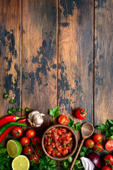 Wall Mural - Tomato salsa (salsa roja) - traditional mexican sauce  with ingredients for making. Top view with copy space.