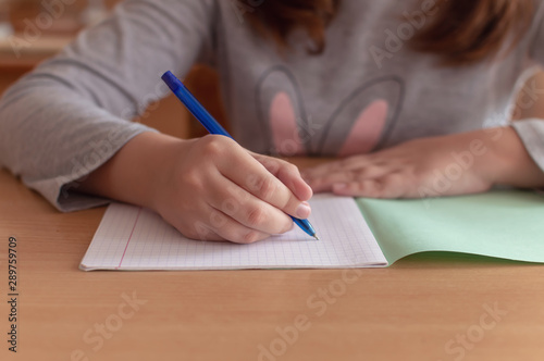 Fotografía hand of a teenage girl writes with a ballpoint pen in a terad during a lesson at