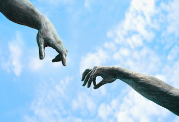 fragment of old statues. minimalism symbol. detail of unknown ancient sculpture. two hands on abstract sky background. soft selective focus