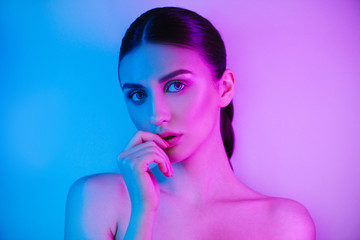 Wall Mural - High Fashion woman in colorful bright neon uv blue and purple lights, posing in studio, beautiful girl, glowing make-up, colorful make up.