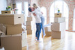 © Krakenimages.com - Young beautiful couple hugging at new home around cardboard boxes