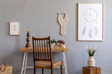 Stylish and design home interior of living room with wooden cube and desk, books, retro chair plants, mock up poster frames, macrame, table lamp and elegant accessories. Stylish home decor. Template. 