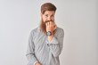 © Krakenimages.com - Young redhead irish man wearing casual shirt standing over isolated white background looking stressed and nervous with hands on mouth biting nails. Anxiety problem.