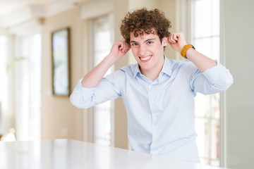 Wall Mural - Young business man with curly read head Smiling pulling ears with fingers, funny gesture. Audition problem