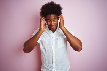 Poster - Young american man with afro hair wearing white shirt standing over isolated pink background with hand on head for pain in head because stress. Suffering migraine.