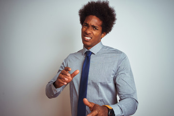 Poster - American business man with afro hair wearing shirt and tie over isolated white background disgusted expression, displeased and fearful doing disgust face because aversion reaction. With hands raised