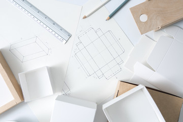 Development design drawing packaging. Desktop of a creative person making cardboard boxes.