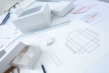 Development design drawing packaging. Desktop of a creative person making cardboard boxes.