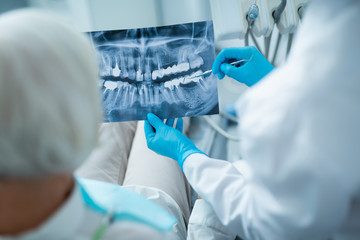 Wall Mural - Dentist is discussing female patient x-ray in clinic