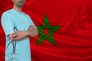 partial photograph of a doctor with stethoscope in a professional medical uniform against the background of the national flag of the state of Morocco, health care concept, activities of the organizati