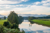 Fototapeta  - Morning nature landscape with freshwater river and mountains in the distance