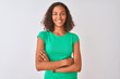 © Krakenimages.com - Young brazilian woman wearing green t-shirt standing over isolated white background happy face smiling with crossed arms looking at the camera. Positive person.