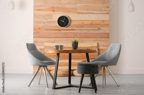 Fotografía Stylish room interior with round table and comfortable chairs