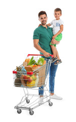 Wall Mural - Father and son with full shopping cart on white background