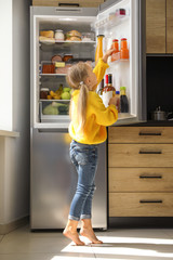 Sticker - Girl taking bottle with juice out of refrigerator in kitchen