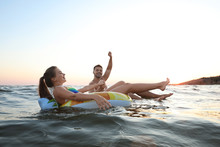 Happy Young Couple On Inflatable Rings In Water