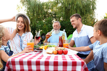 Wall Mural - Happy family having barbecue in park on sunny day