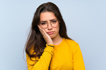 Wall Mural - teenager girl over isolated blue wall unhappy and frustrated