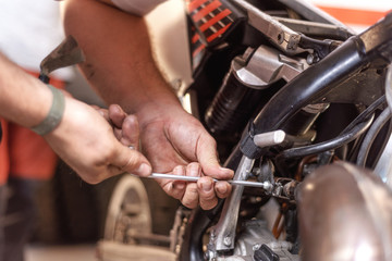 Wall Mural - Mechanic Repairing A Motorbike Engine In A Workshop .